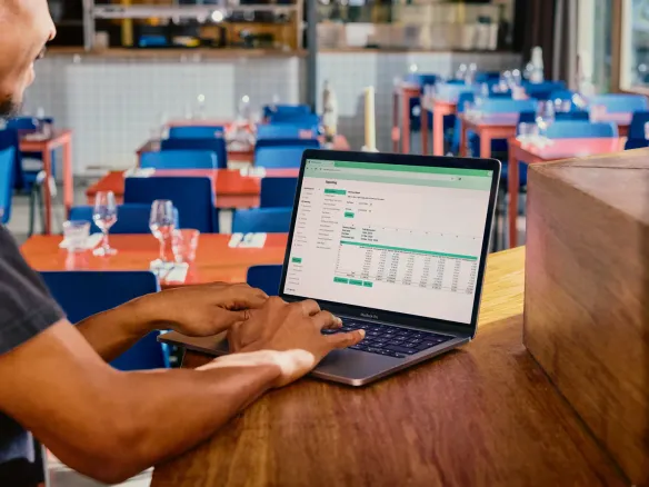 Man in front of laptop with paper notebook